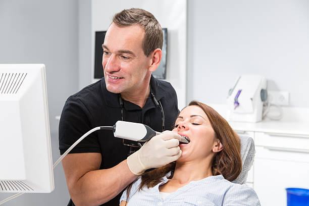 a dental professional performing a dental exam and showing his patient